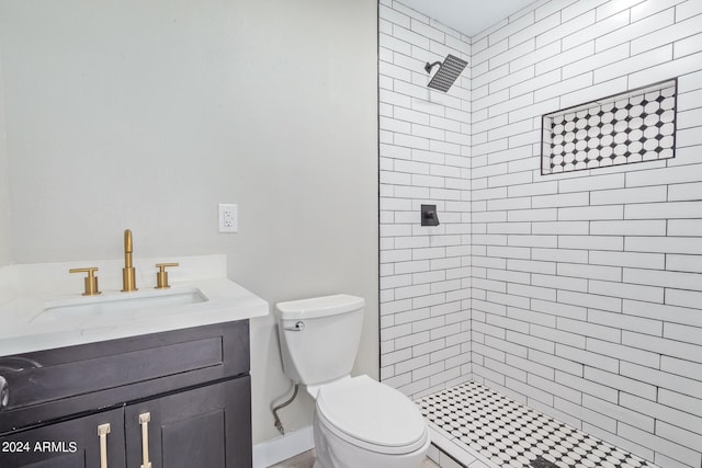 bathroom featuring vanity, toilet, and tiled shower