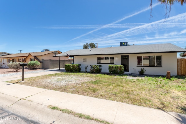 ranch-style house with a front yard and a carport