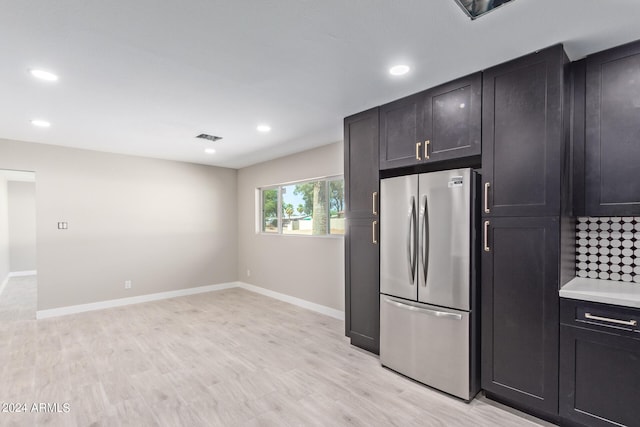 kitchen with stainless steel fridge and light hardwood / wood-style floors