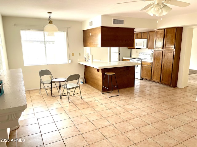 4330 E Beck Ln, Phoenix, AZ 85032 - kitchen featuring visible vents, a peninsula, white appliances, a ceiling fan, and a breakfast bar area
