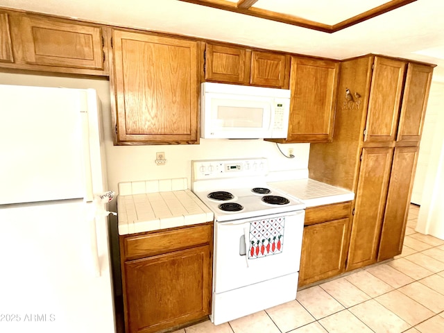 4330 E Beck Ln, Phoenix, AZ 85032 - kitchen with light tile patterned flooring, tile countertops, brown cabinetry, and white appliances