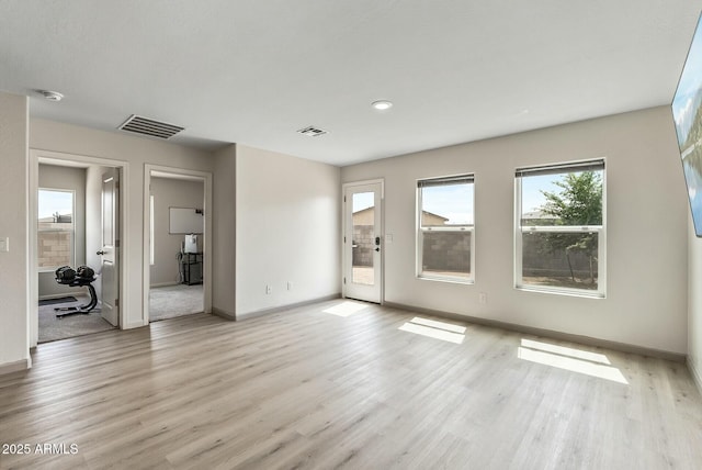 459 Brandeis Dr, Morristown, AZ 85342 - unfurnished living room with plenty of natural light, visible vents, and light wood-style floors