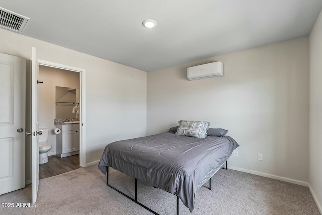 459 Brandeis Dr, Morristown, AZ 85342 - bedroom featuring a wall mounted AC, baseboards, ensuite bath, carpet flooring, and visible vents