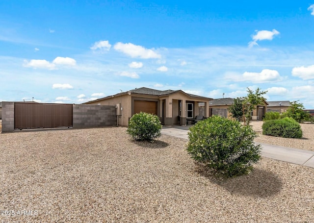 459 Brandeis Dr, Morristown, AZ 85342 - view of front facade featuring a gate, fence, stucco siding, driveway, and a garage