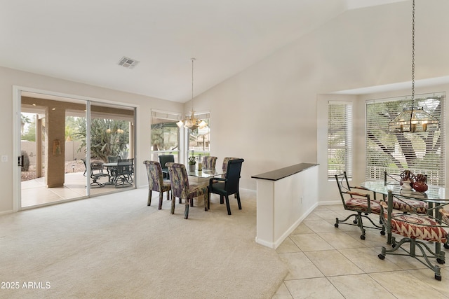 tiled dining room featuring vaulted ceiling and a chandelier