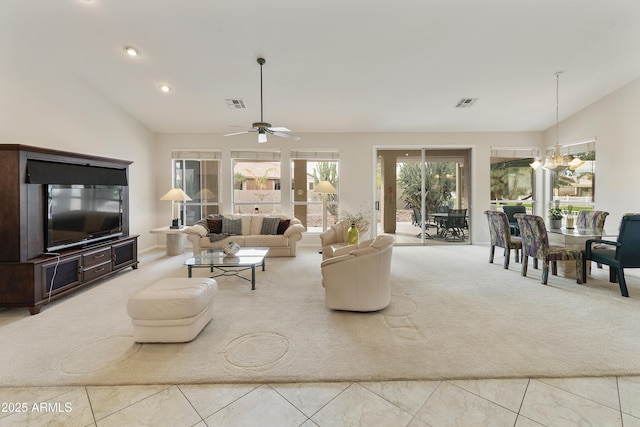 living room with ceiling fan with notable chandelier, light colored carpet, and lofted ceiling