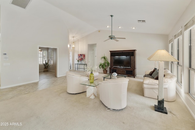 tiled living room featuring vaulted ceiling and ceiling fan with notable chandelier