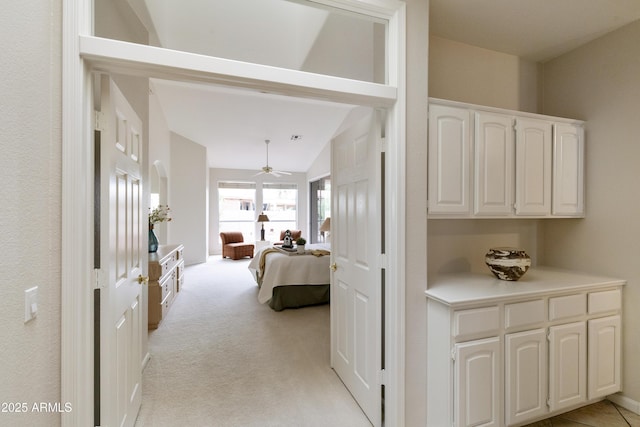 hall featuring lofted ceiling and light carpet