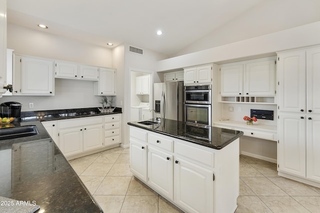 kitchen with white cabinetry, washer and clothes dryer, stainless steel appliances, and lofted ceiling