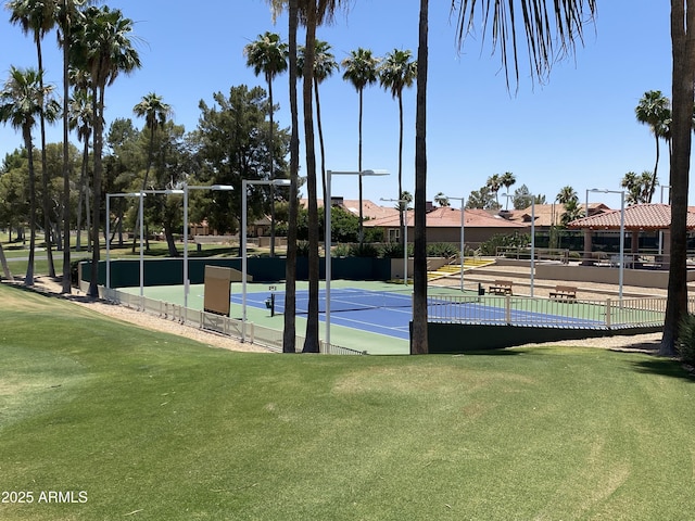 view of tennis court featuring a yard