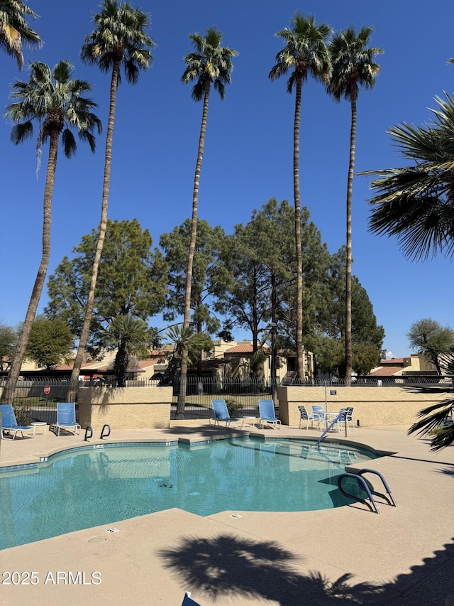 community pool featuring a patio and fence