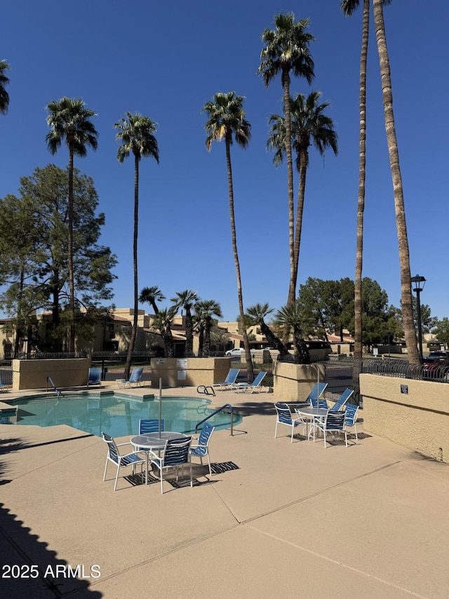 community pool featuring a patio area and fence