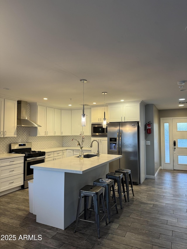 7635 E Verde Ln, Scottsdale, AZ 85251 - kitchen with appliances with stainless steel finishes, white cabinets, backsplash, a sink, and wall chimney exhaust hood
