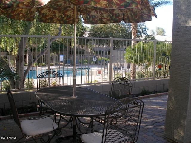 view of patio / terrace featuring a community pool and fence