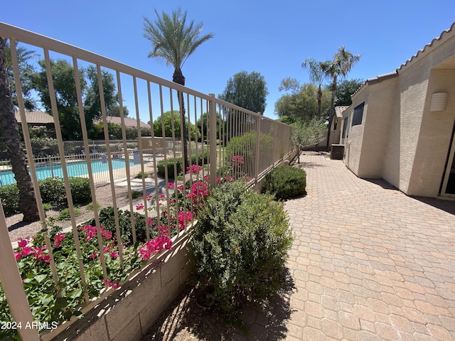 view of patio featuring a community pool and fence