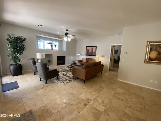 living area with visible vents, a fireplace, baseboards, and a ceiling fan