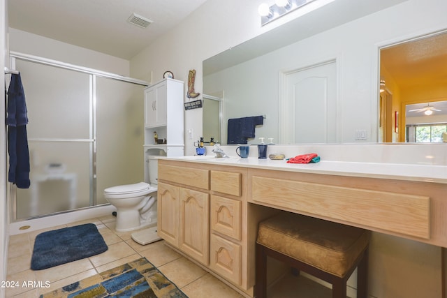 bathroom with vanity, toilet, a shower with door, and tile patterned floors