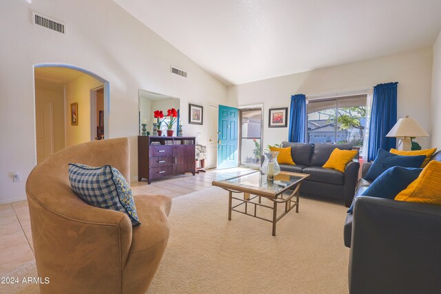 tiled living room featuring high vaulted ceiling