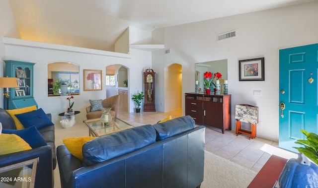 living room with high vaulted ceiling and light tile patterned floors