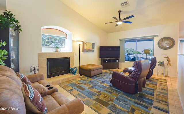 living room featuring high vaulted ceiling, a wealth of natural light, tile patterned flooring, and a tile fireplace