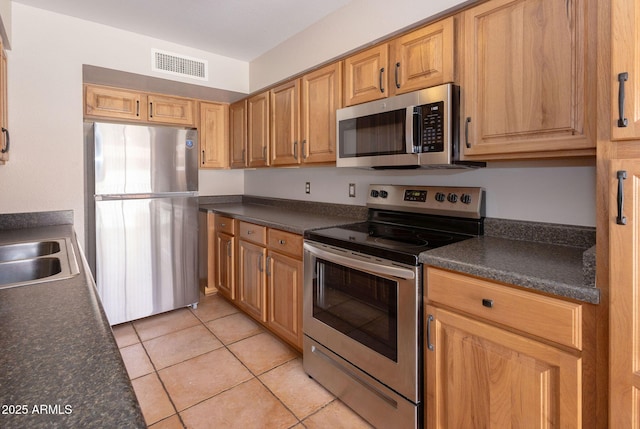 kitchen featuring light tile patterned floors, sink, and appliances with stainless steel finishes