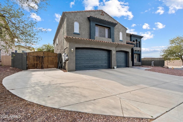 12943 W Mclellan Rd, Glendale, AZ 85307 - mediterranean / spanish-style home featuring stucco siding, a tiled roof, a gate, a garage, and driveway