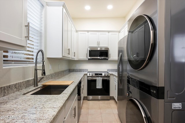 12943 W Mclellan Rd, Glendale, AZ 85307 - kitchen featuring white cabinetry, stacked washer and clothes dryer, appliances with stainless steel finishes, and a sink
