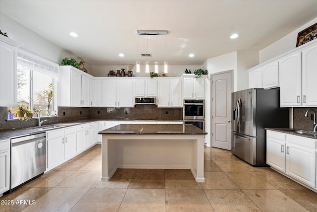 12943 W Mclellan Rd, Glendale, AZ 85307 - kitchen featuring dark stone counters, a sink, stainless steel appliances, decorative backsplash, and white cabinets
