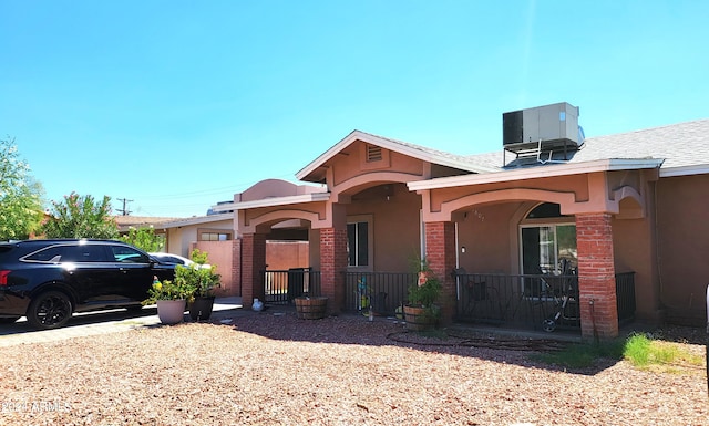 ranch-style home with a fenced front yard, stucco siding, and central air condition unit