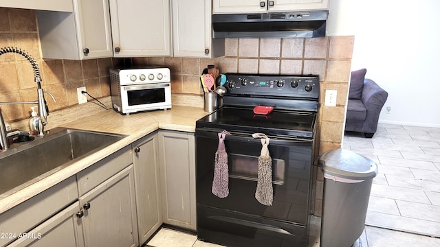 kitchen featuring gray cabinetry, sink, electric range, and decorative backsplash