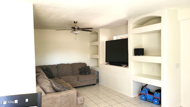 living room with ceiling fan, a textured ceiling, built in features, and light tile patterned floors