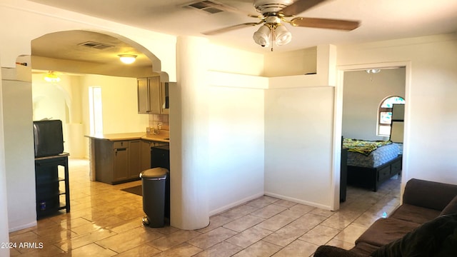 kitchen with arched walkways, visible vents, light countertops, and a ceiling fan