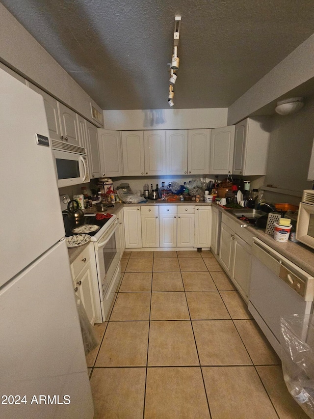 kitchen featuring white cabinetry, sink, a textured ceiling, light tile patterned floors, and white appliances