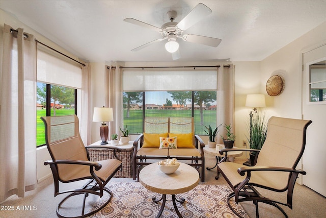 living area with light carpet and a ceiling fan