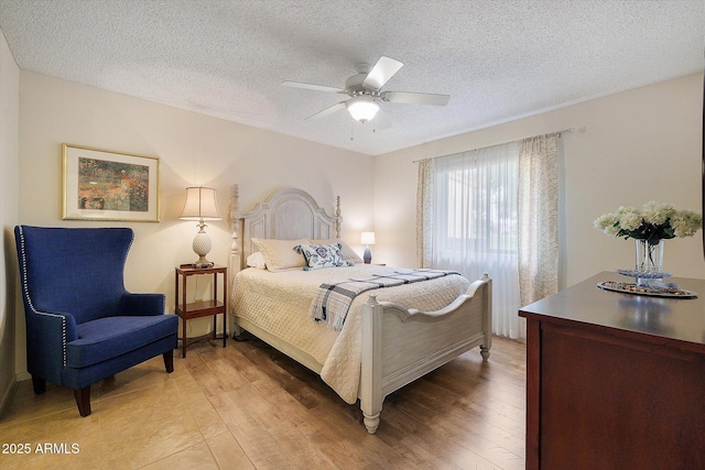 bedroom featuring light wood-type flooring, a textured ceiling, and ceiling fan