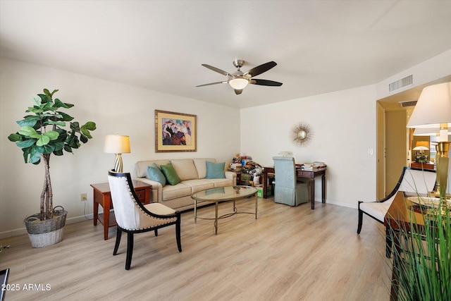 living area with baseboards, visible vents, light wood finished floors, and ceiling fan