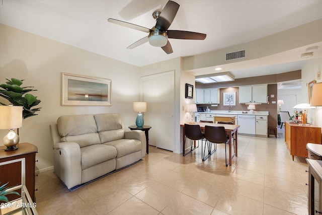 living room featuring light tile patterned floors, visible vents, baseboards, and ceiling fan