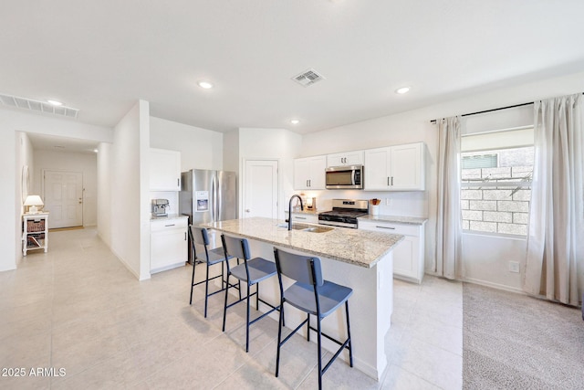 4911 N 193rd Ave, Litchfield Park, AZ 85340 - kitchen featuring stainless steel appliances, a sink, a kitchen breakfast bar, a center island with sink, and light tile patterned flooring