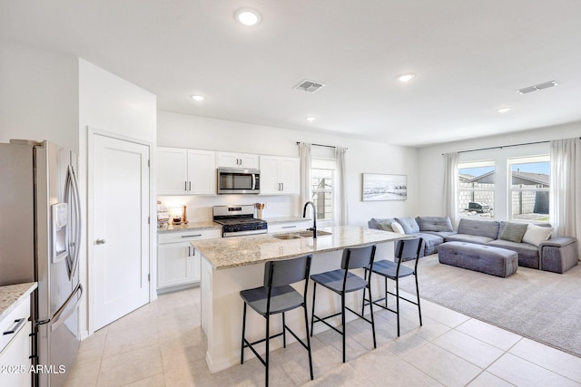 4911 N 193rd Ave, Litchfield Park, AZ 85340 - kitchen with appliances with stainless steel finishes, a sink, a kitchen breakfast bar, open floor plan, and healthy amount of natural light