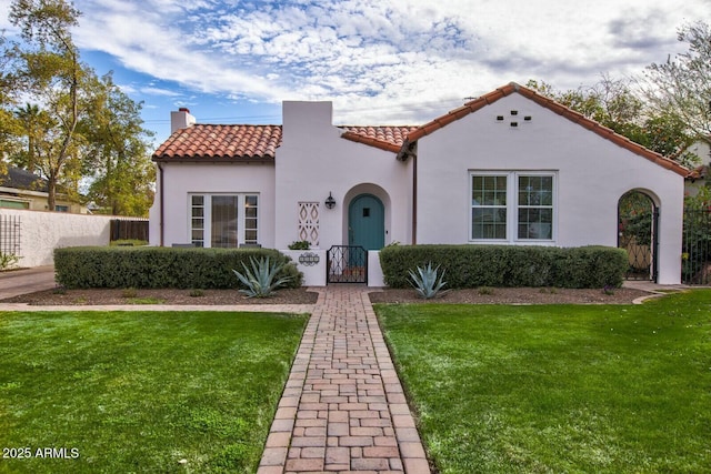 mediterranean / spanish house with a front lawn