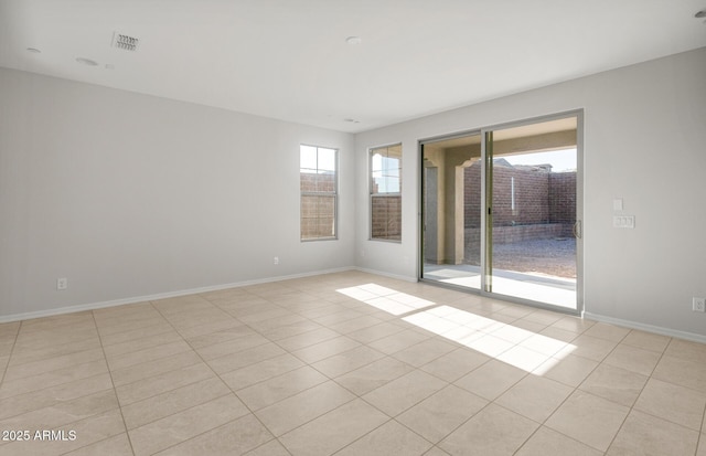 unfurnished room featuring light tile patterned flooring, baseboards, and visible vents
