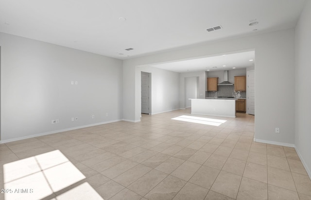 unfurnished living room with baseboards, visible vents, and light tile patterned floors
