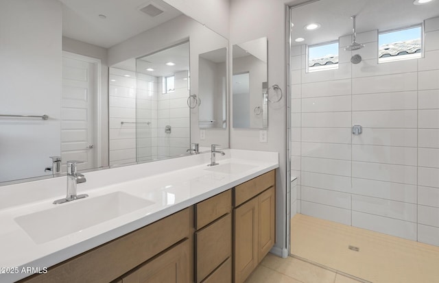 bathroom featuring a sink, tiled shower, and visible vents