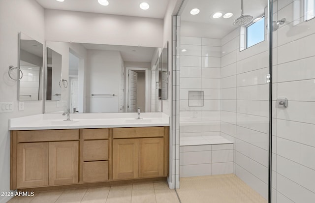 bathroom featuring double vanity, a shower stall, a sink, and tile patterned flooring