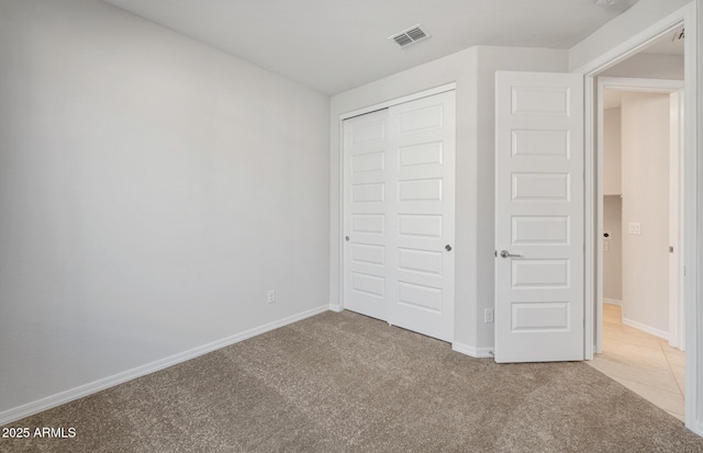 unfurnished bedroom featuring a closet, carpet, and baseboards