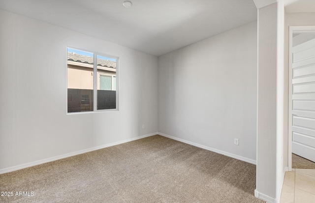 empty room with baseboards and light carpet