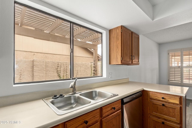 9845 W Behrend Dr, Peoria, AZ 85382 - kitchen featuring light countertops, a sink, dishwasher, a peninsula, and brown cabinetry