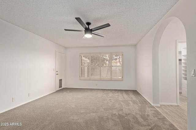 9845 W Behrend Dr, Peoria, AZ 85382 - carpeted spare room with arched walkways, a textured ceiling, baseboards, and ceiling fan