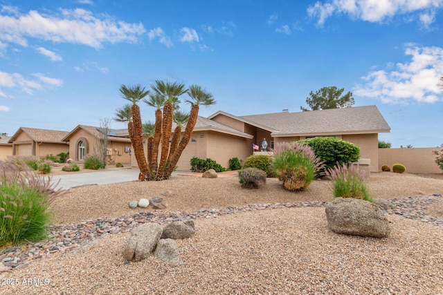 9845 W Behrend Dr, Peoria, AZ 85382 - view of front of house featuring roof mounted solar panels, driveway, stucco siding, and an attached garage