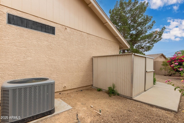 9845 W Behrend Dr, Peoria, AZ 85382 - view of home's exterior featuring an outdoor structure, a storage unit, stucco siding, and central AC